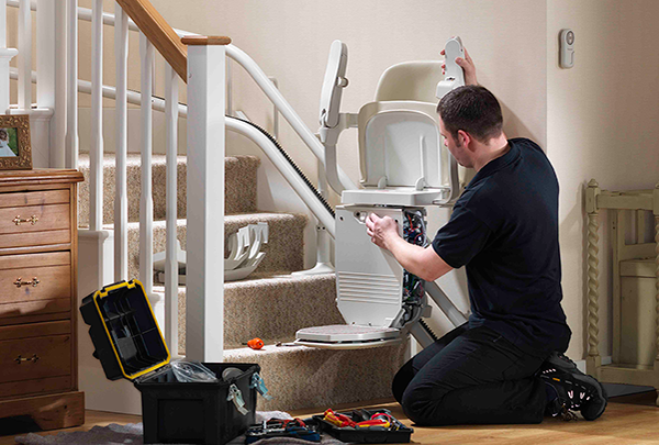 A Stannah engineer is inspecting a stair lift 