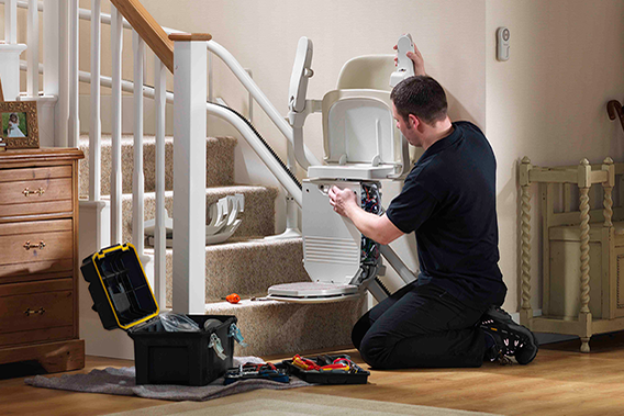 man knelt down with toolbox open on the floor working on the stairlift