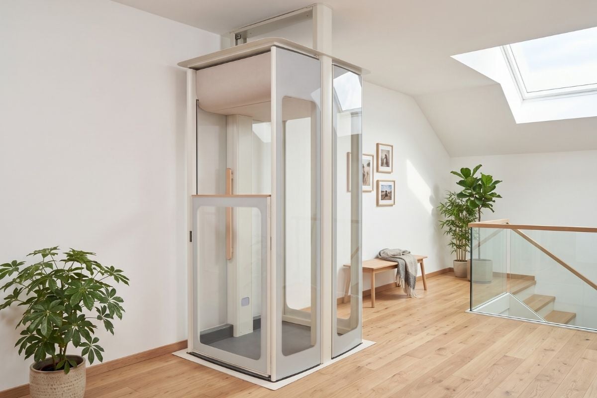 Ascenseur privatif Uplifts par Stannah avec cabine vitrée et finitions bois, intégré dans un palier moderne et lumineux.