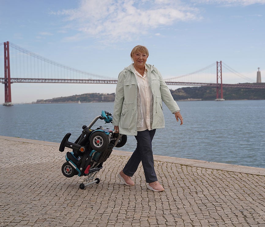 Pessoa a levar uma scooter de mobilidade reduzida dobrada