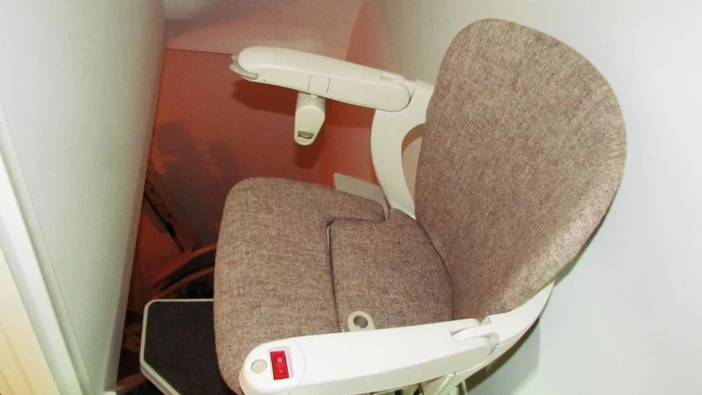 traplift smalle steile trap stoel Mevrouw gaat comfortabel met haar traplift - en gewatteerde stoel - gebruik van haar trap maken