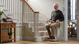 stairlift at bottom of stairs with table in picture