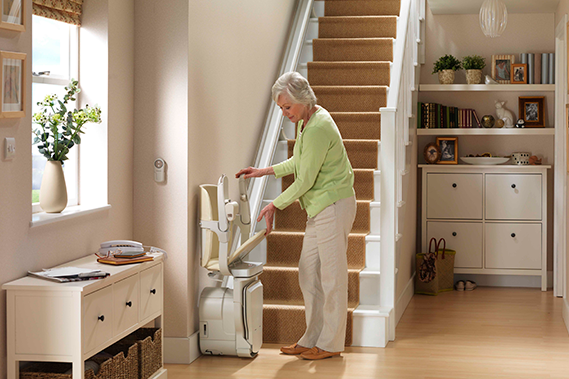 lady folding stairlift in hallway