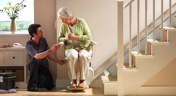 Man talking with lady and showing how to use stairlift