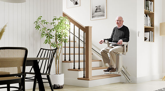 man on stairlift with green top dining table and black chairs